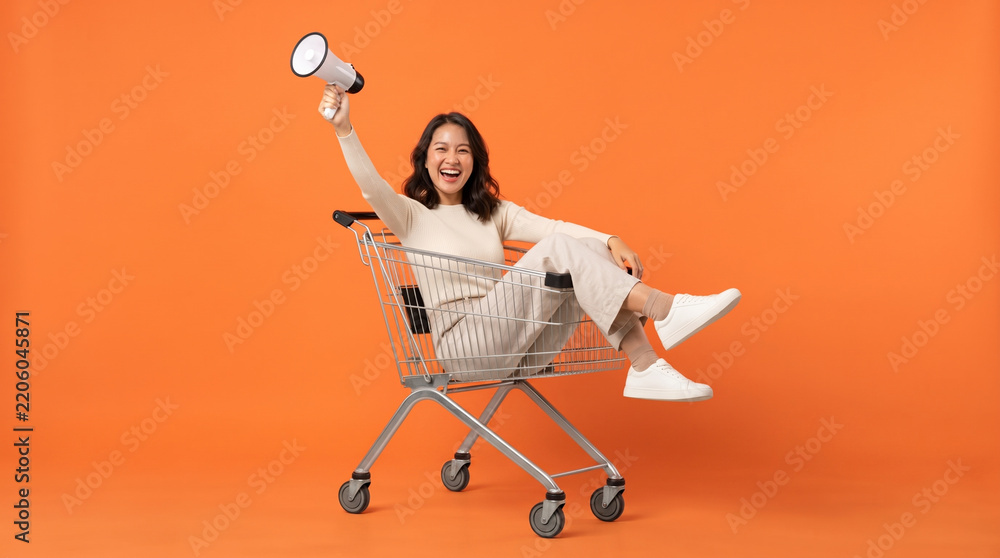 Fototapeta premium Excited Woman Celebrating in Shopping Cart with Megaphone