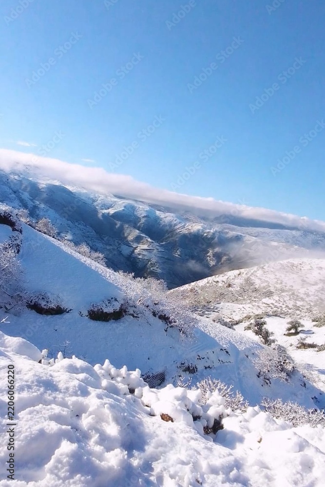 Obraz premium Snow Covered Mountain Landscape in Morocco with Blue Sky and Frosty Trees