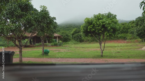 Rainy Rural Landscape with Green Field and Cloudy Mountain Background