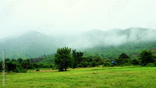 Moving Clouds Across Green Mountain and Open Rice Field Landscape