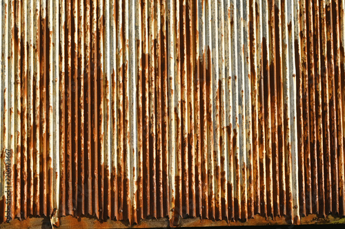 Texture or background of Rusted, aged galvanized sheet metal wall surface; weathered galvanized steel fence; retro concept; the artistry of old, rusty galvanized sheeting; vintage-style metal panels.