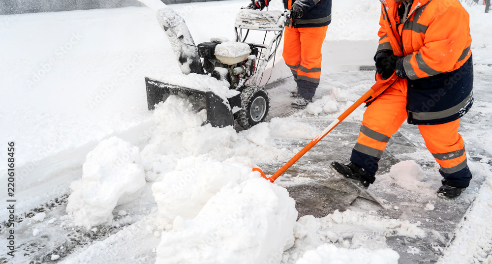 Obraz premium Snow removal workers clear icy streets