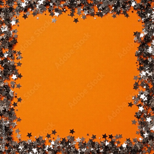 Orange background with a border of silver star confetti 