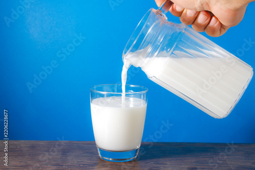 Fresh Milk Being Poured Into a Clear Glass on a Bright Background