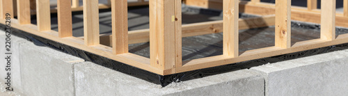 wooden frame house foundation concrete blocks showcasing black waterproofing details wooden structure bright