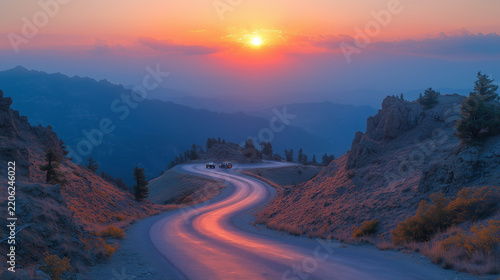 Winding mountain road at sunset with light trails