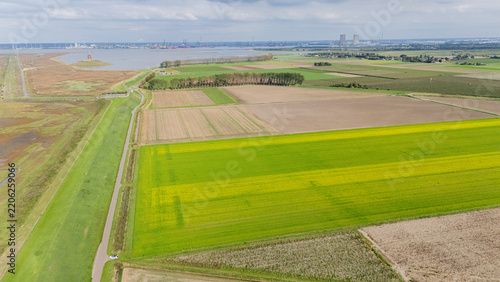 Aerial view showing doel nuclear power station towers and industrialized harbor area contrasting with agricultural fields and wetlands