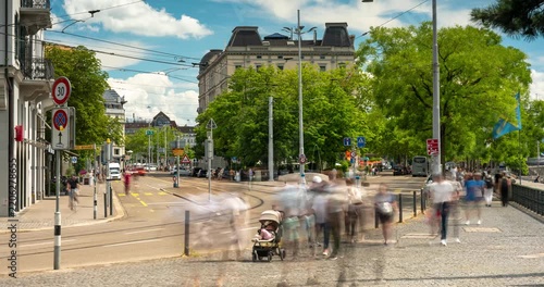 Zurich city street time lapse featuring classic architecture, rushing summer clouds, and motion blurred urban transit