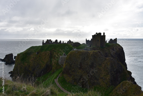 Powerful Ocean Waves Crash Below Silhouetted Scottish Castle