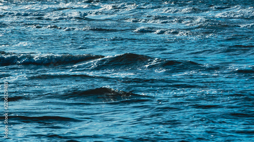 Obraz na plátně Choppy ocean water surface texture background with white foam waves