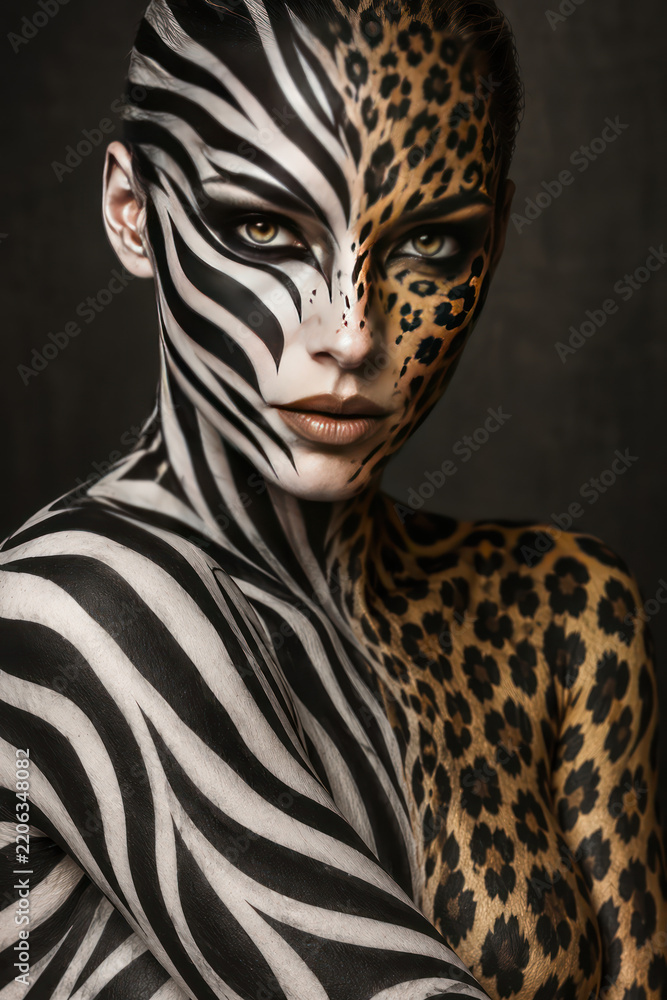Fototapeta premium Zebra and Leopard Body Paint Portrait Symbolizing Duality and Wild Nature