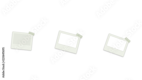 Polaroid photo frames taped to a clean white background. Three empty instant picture frames secured with adhesive tape. Minimalist layout for displaying memories and creative projects