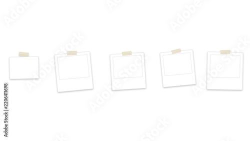 Blank instant photo frames taped to a white wall. Five empty polaroid picture templates with adhesive masking tape. Blank photography placeholders for scrapbooking layouts and digital art