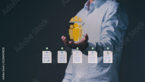 Corporate manager holding a virtual hologram of a construction workforce team and approved digital documents for a human resources, tax, and legal compliance management system.