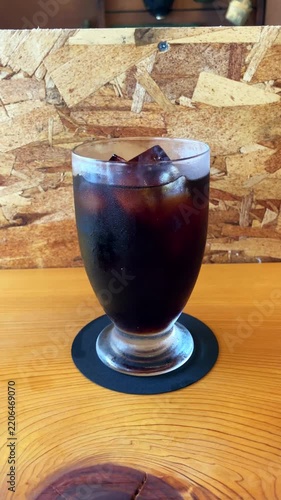 木製のテーブルに置かれた冷たいアイスコーヒーのグラス