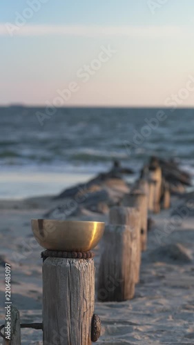 Sound therapy singing bowl by the ocean at sunset