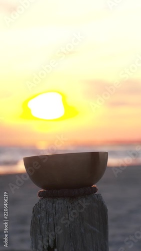 Singing bowl at sunset by the ocean