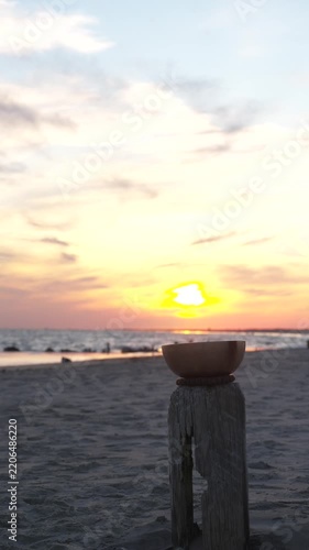 Meditation bowl on beach at sunset