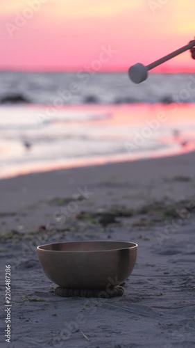 Singing bowl on beach at sunset by the ocean