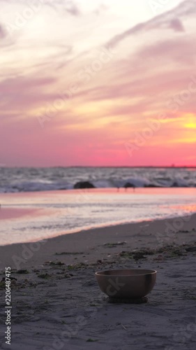 Sound healing bowl on beach at sunset