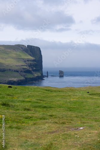 View of Risin og Kellingin or The Giant and the Witch , Standing Stone at the northern coast of the island of Eysturoy in the Faroe Islands in Summer