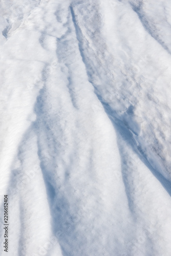 Snow ice. the ice crust. Close-up view of fresh, fluffy snow covering the ground, showcasing a textured surface with varying shades of white and soft contours