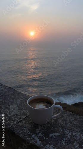 Cup of Coffee at Sunrise Over the Ocean