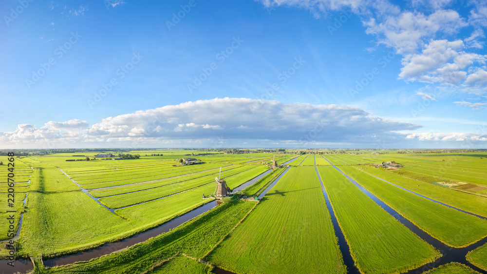 Fototapeta premium Aerial drone view of traditional windmills in the Netherlands. Panoramic view. Green fields and rural countryside landscape in the Dutch region.