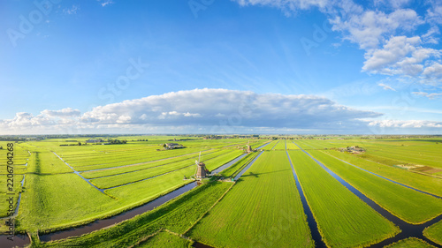 Aerial drone view of traditional windmills in the Netherlands. Panoramic view. Green fields and rural countryside landscape in the Dutch region.