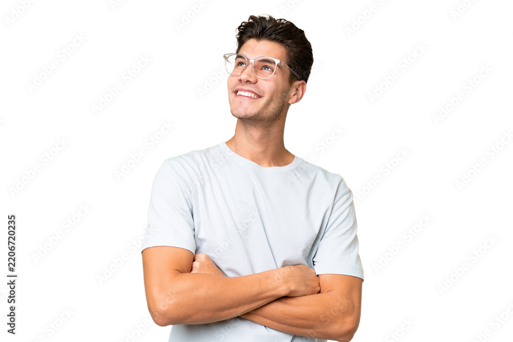 Obraz premium Young caucasian handsome man over isolated background looking up while smiling