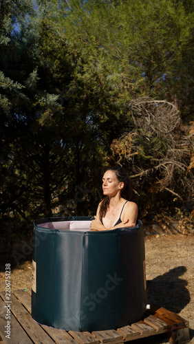 Woman enjoying cold plunge ice bath outdoors wellness