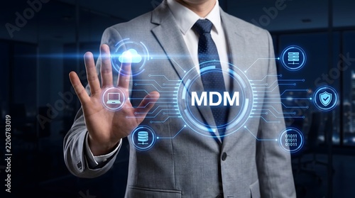 Man in business suit interacting with a futuristic digital interface displaying MDM and technology icons representing mobile device management and data security in a corporate environment.