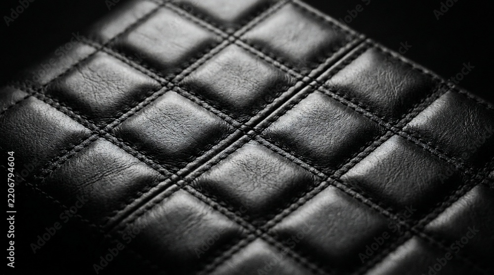 Fototapeta premium Premium black quilted faux leather texture with elegant square stitching and dramatic lighting for fashion interior design background