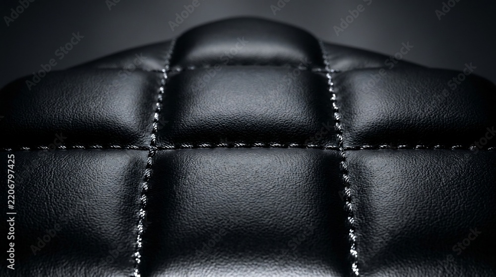 Fototapeta premium Dark luxury black faux leather texture with quilted pattern and white stitching macro shot for furniture or automotive background.