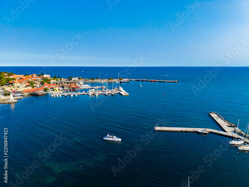 Fotografie View of a coastal town along the water with boats in the harbor during a clear d