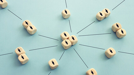 Wooden cubes with people icons over blue background, human resources and management concept
