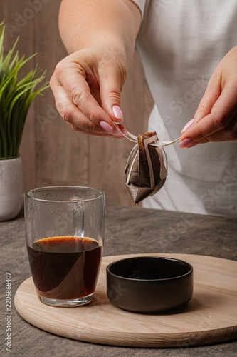 Woman Holding Wet Drip Coffee Pouch Over Glass Cup