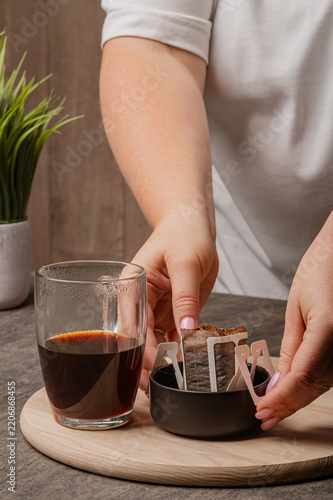 Placing Used Drip Coffee Bag into Small Ceramic Bowl