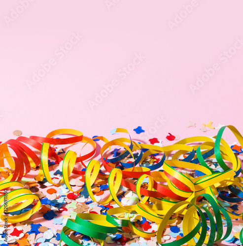 Colorful Paper Streamers and Scattered Confetti on Pink Background