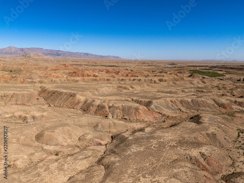Fotografie arid canyon yellow landform landscape with eroded hills and vast plains under bl