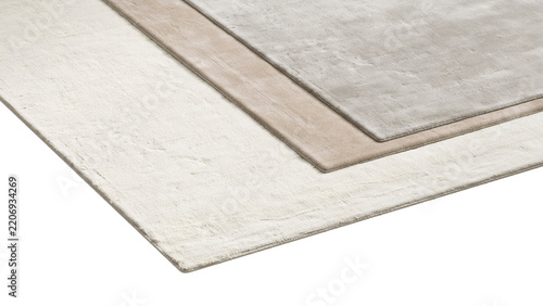 Stack of rectangular viscose rugs in different sizes and neutral shades, layered one over another with soft textures and subtle tonal variations, shown as a 3D render and visualization.