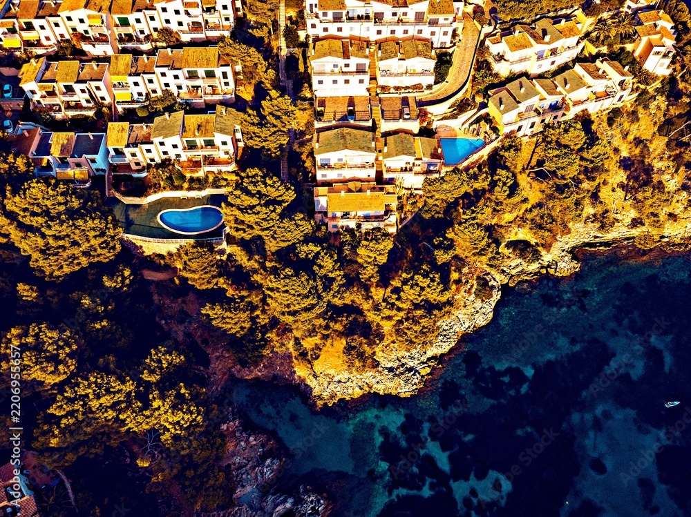 Obraz premium Aerial view of coastal villas with swimming pools and ocean