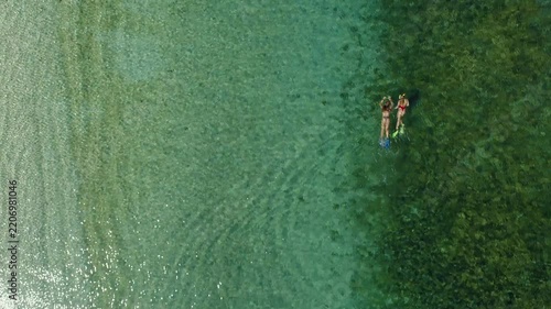 Aerial drone shot showing two young women snorkeling in the turquoise waters of the Pacific Ocean near Coiba Island in Panama, a popular destination for aquatic sports and eco-tourism - stock video