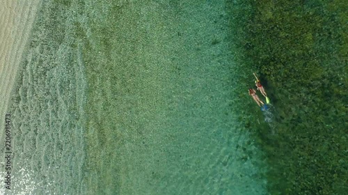 Top-down aerial view of two women snorkeling and swimming in the clear, shallow water of the Pacific Ocean near Coiba Island, Panama, enjoying a tropical vacation and outdoor activity - stock video