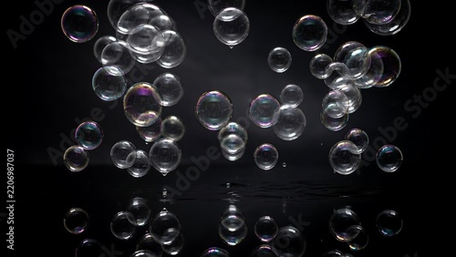 Floating soap bubbles in midair creating colorful reflections against transparent background