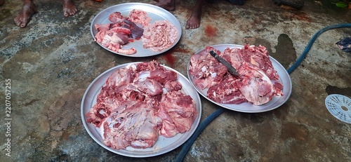 Fotografie Freshly cut raw meat and offal arranged on metal trays outdoors
