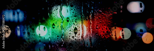 Abstract rain drops on window glass, colorful city night bokeh lights behind, blurred neon blue red purple orange circles, water condensation texture, dreamy moody urban night photography wallpaper ar