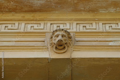 neoclassical building facade detail meander pattern and lion animal head mascaron architectural decorative element