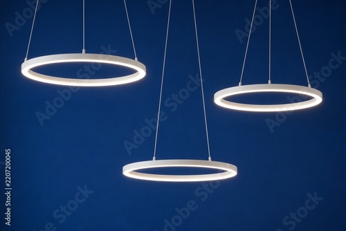 Pendant ring lights suspended over dark blue background