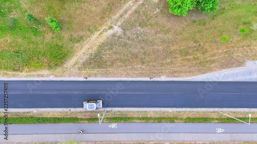 Aerial Top-Down View of a Road Roller Paving Fresh Asphalt on a New Road